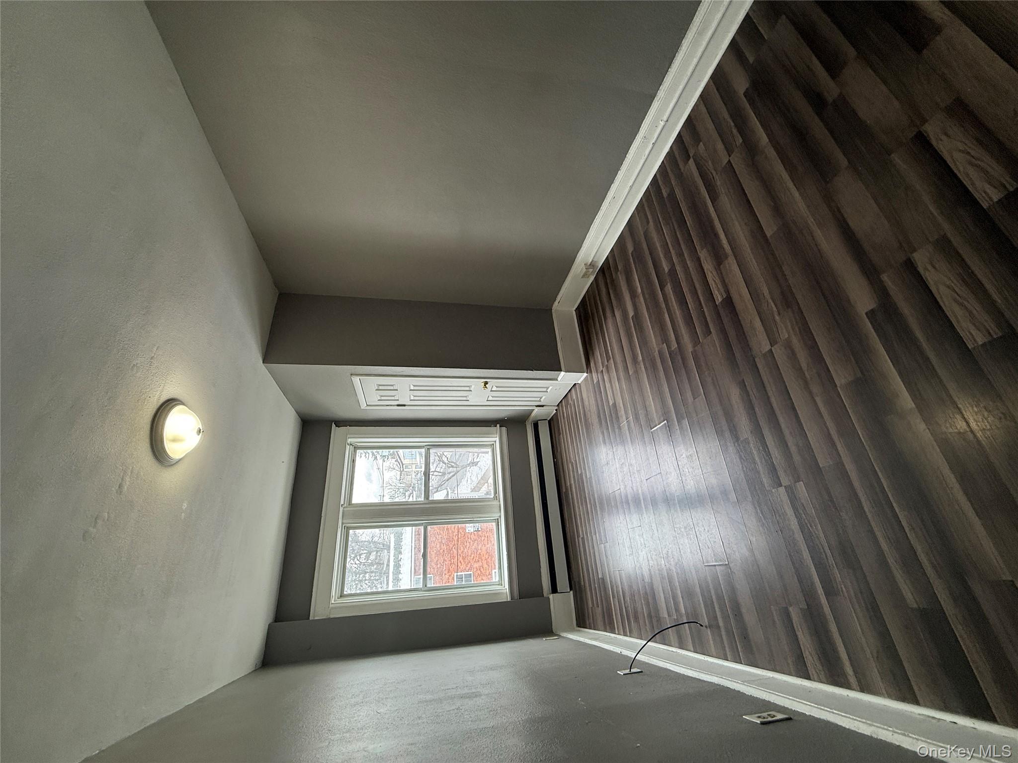 60 Carroll Street, Unit C3 Poughkeepsie, NY 12601 - Photo 8 of 19 wooden floor in an empty room with a window