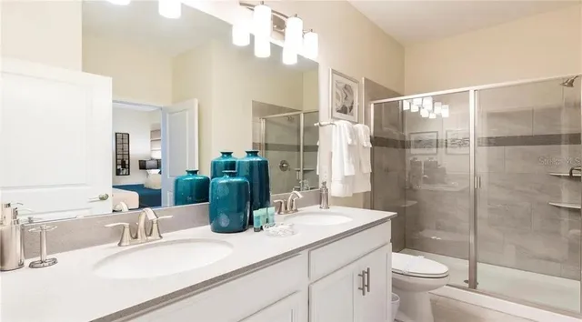 a bathroom with a double vanity sink toilet and shower