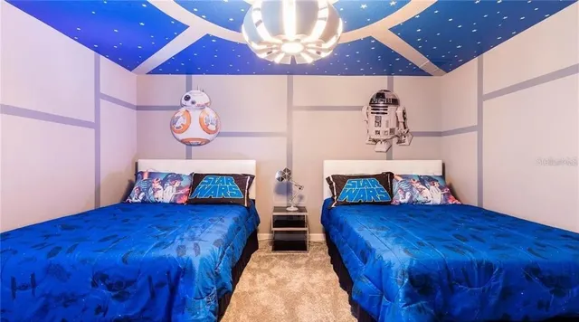 a bedroom with two beds and a chandelier