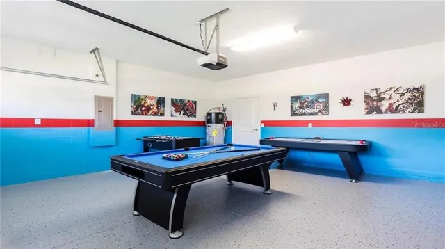 a room with furniture pool table and wall paintings