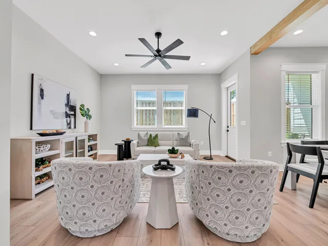 a living room with furniture a large window and a chandelier