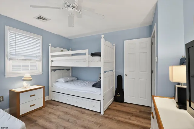 a bedroom with a bed and a flat tv screen on dresser