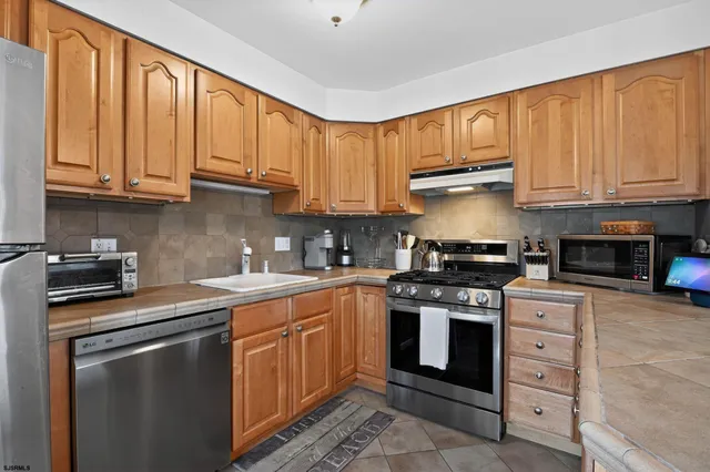 a kitchen with stainless steel appliances granite countertop a stove sink and cabinets