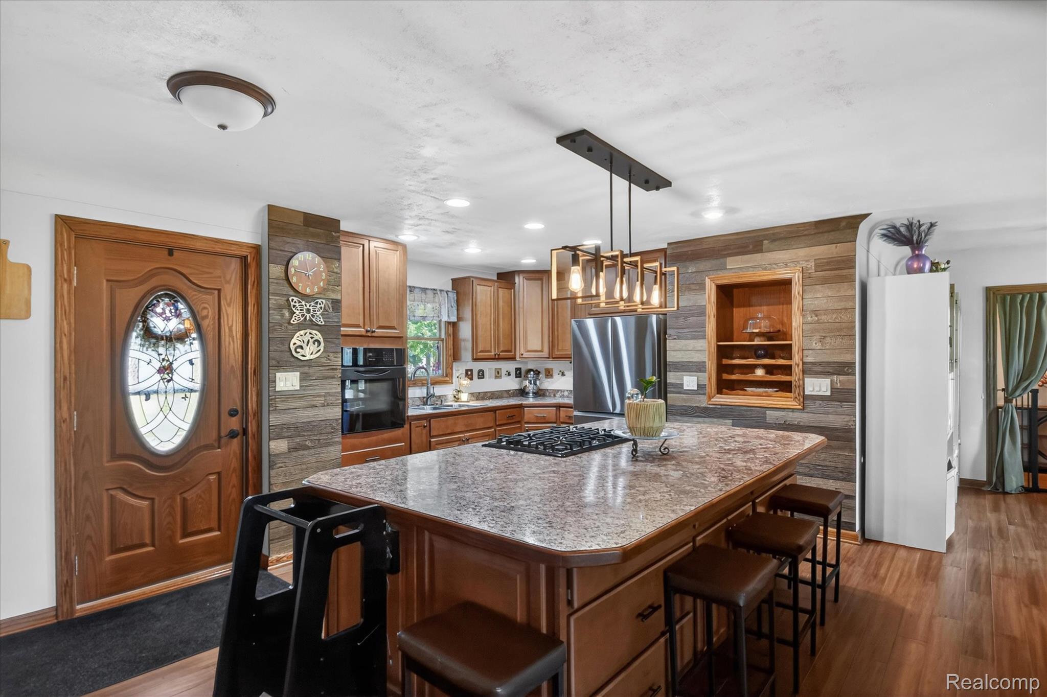 3949 West Burns Line Road Brown City, MI 48416 - Photo 22 of 70 Kitchen featuring a central island with a gas cooktop, pendant lighting, built-in wall oven, wood cabinetry, and a wood-finish flooring
