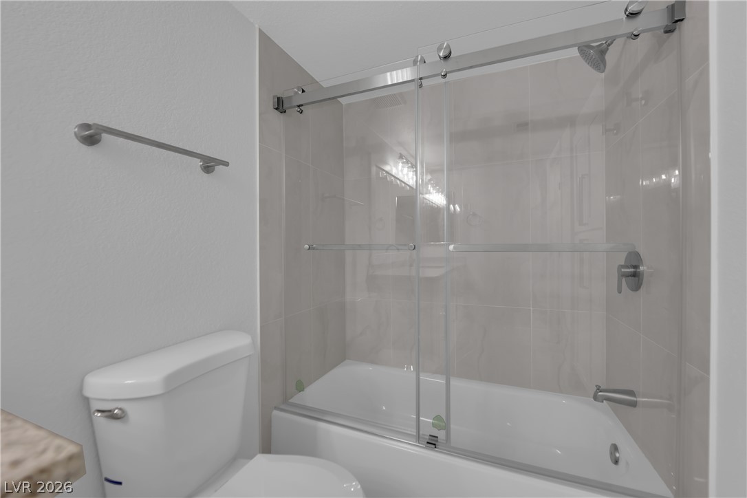 8101 West Flamingo Road, Unit 2152 Las Vegas, NV 89147 - Photo 21 of 45 A well-appointed bathroom features a bathtub and shower combination with sleek sliding glass doors.