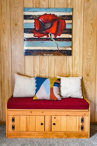 a bedroom with a bed and a painting on the wall with wooden floor