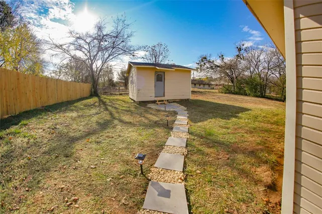 a view of an house with backyard and trees
