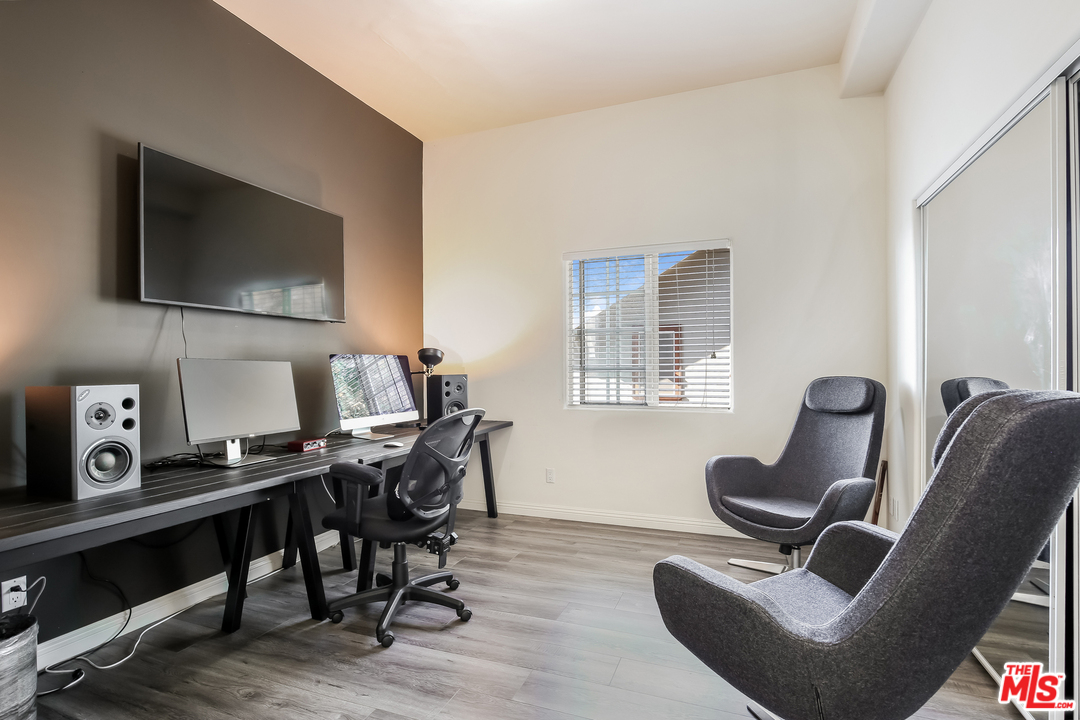 1643 Buckingham Road Los Angeles, CA 90019 - Photo 13 of 26 a work room with furniture and a flat screen tv