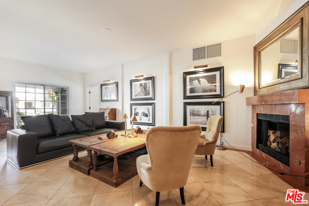 1643 Buckingham Road Los Angeles, CA 90019 - Photo 3 of 26 a living room with furniture a fireplace and a flat screen tv
