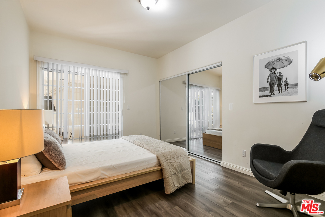 1643 Buckingham Road Los Angeles, CA 90019 - Photo 7 of 26 a bedroom with a bed and wooden floor