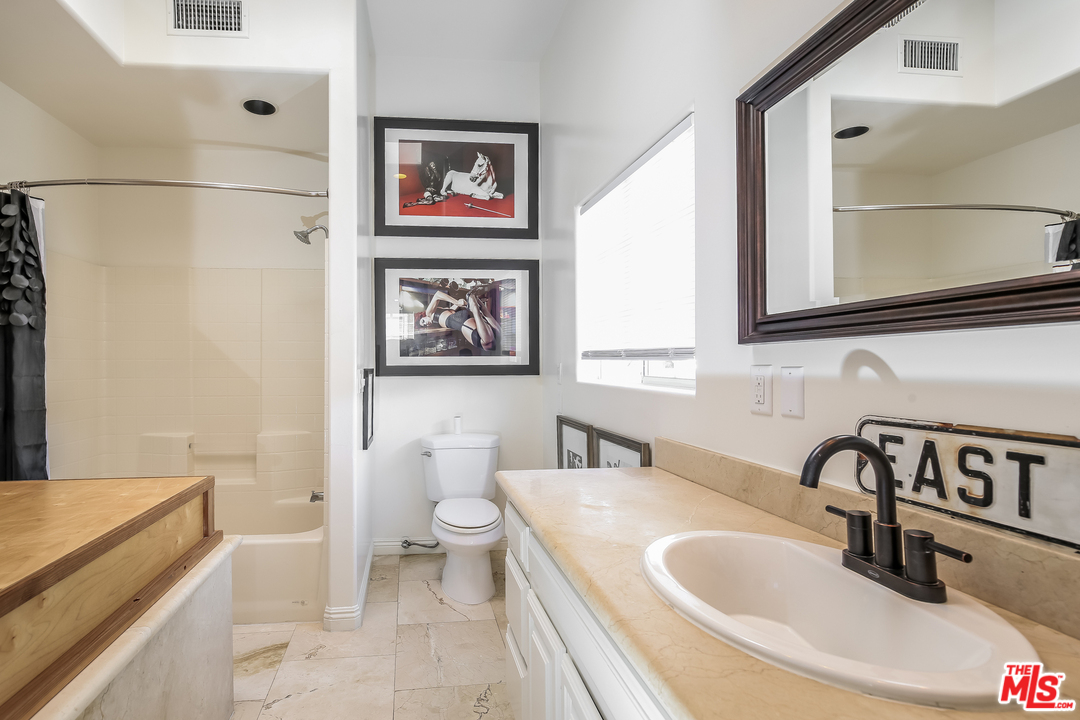 1643 Buckingham Road Los Angeles, CA 90019 - Photo 9 of 26 a bathroom with a sink and a bathtub