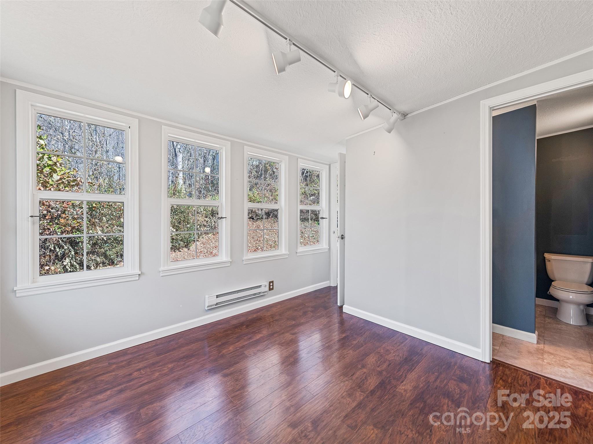 93 Merry Way Clyde, NC 28721 - Photo 16 of 24 an empty room with wooden floor and windows