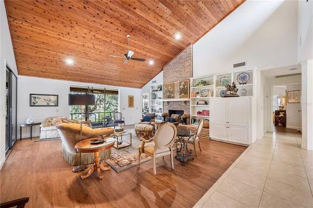 a living room with furniture large windows and wooden floor