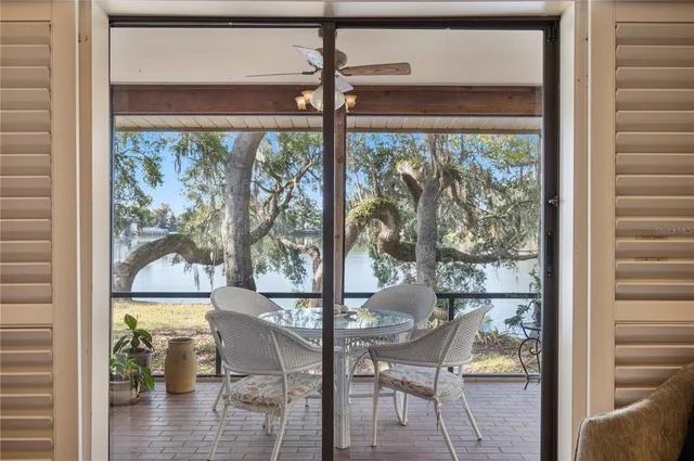 a view of a living room and floor to ceiling windows with wooden floor