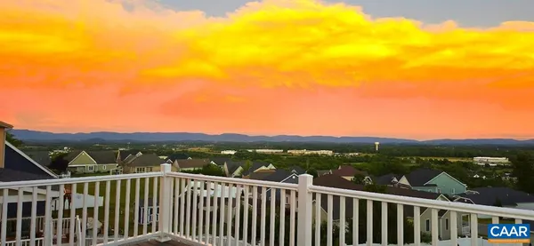 a kitchen with stainless steel appliances kitchen island a table chairs in it and wooden floors