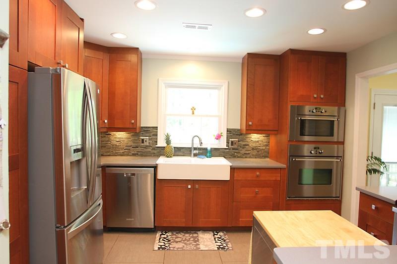 905 Tyrrell Road Raleigh, NC 27609 - Photo 5 of 13 a kitchen with stainless steel appliances granite countertop a refrigerator a stove and a sink with wooden floor