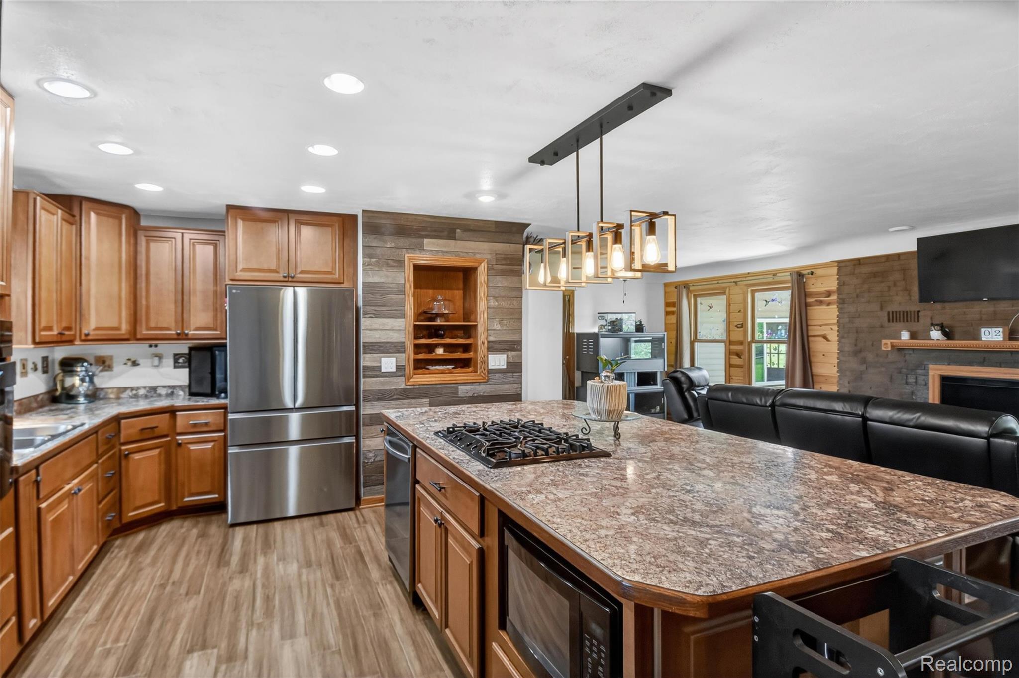 3949 West Burns Line Road Brown City, MI 48416 - Photo 16 of 70 Spacious kitchen featuring an expansive island with an integrated cooktop, wood-finish flooring, and natural wood cabinetry