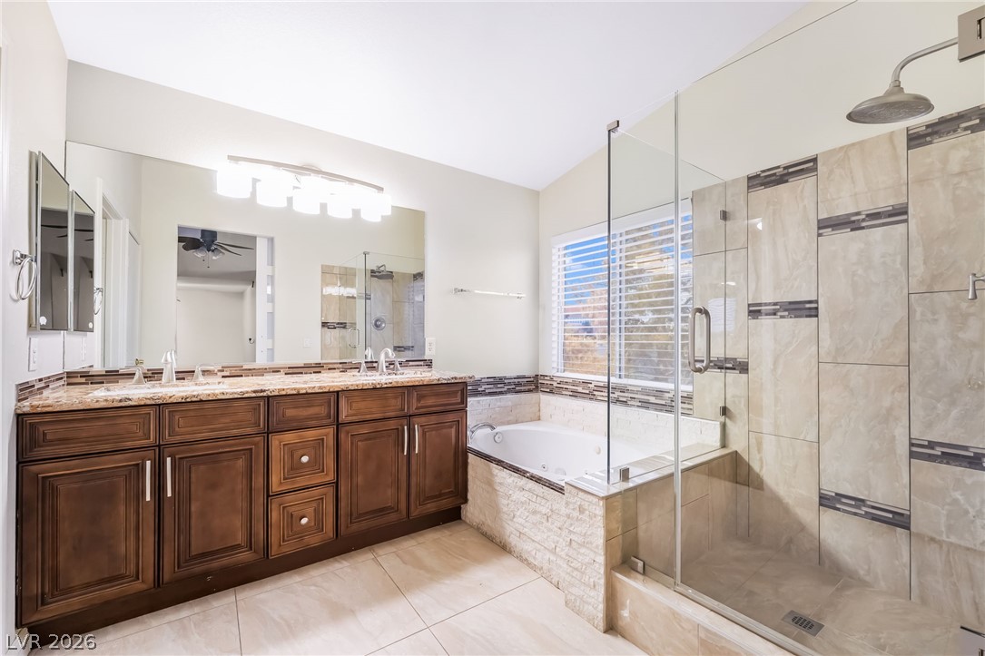5905 Crumbling Ridge Street Henderson, NV 89011 - Photo 18 of 28 An alcove bathtub and a separate glass-enclosed shower stall complete this dual-vanity bathroom.