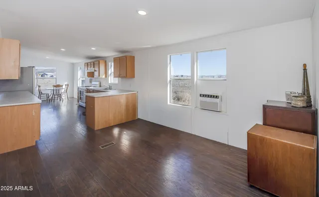 a view of a kitchen with kitchen island a sink wooden floor and a counter top space