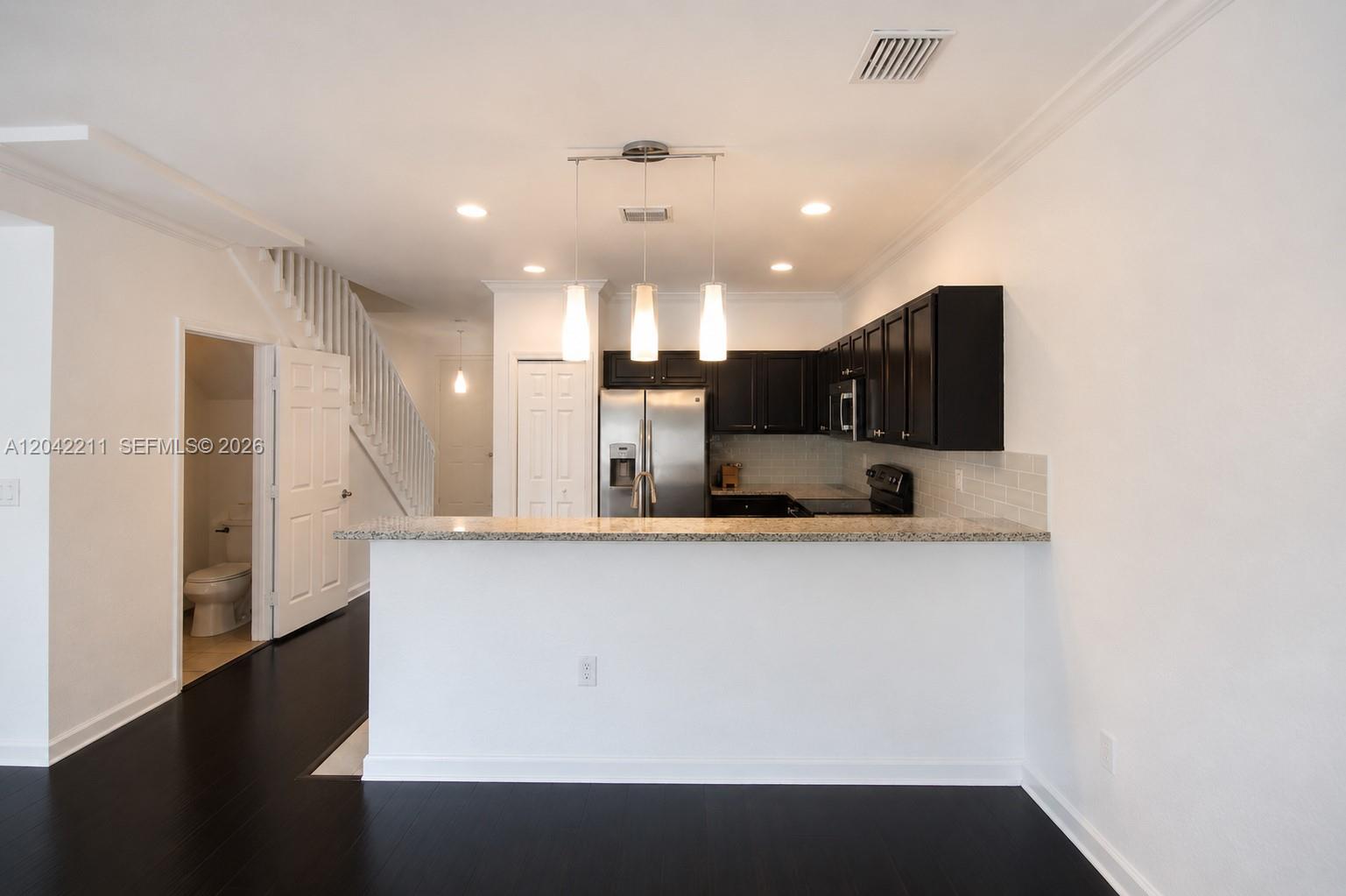 8954 West 35th Way Hialeah, FL 33018 - Photo 8 of 24 a large kitchen with stainless steel appliances a refrigerator and a stove