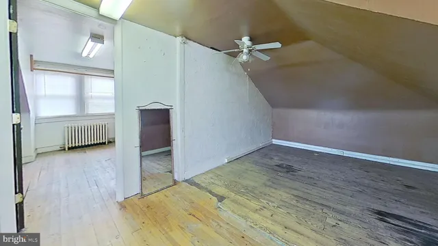 an empty room with wooden floor cabinet and windows