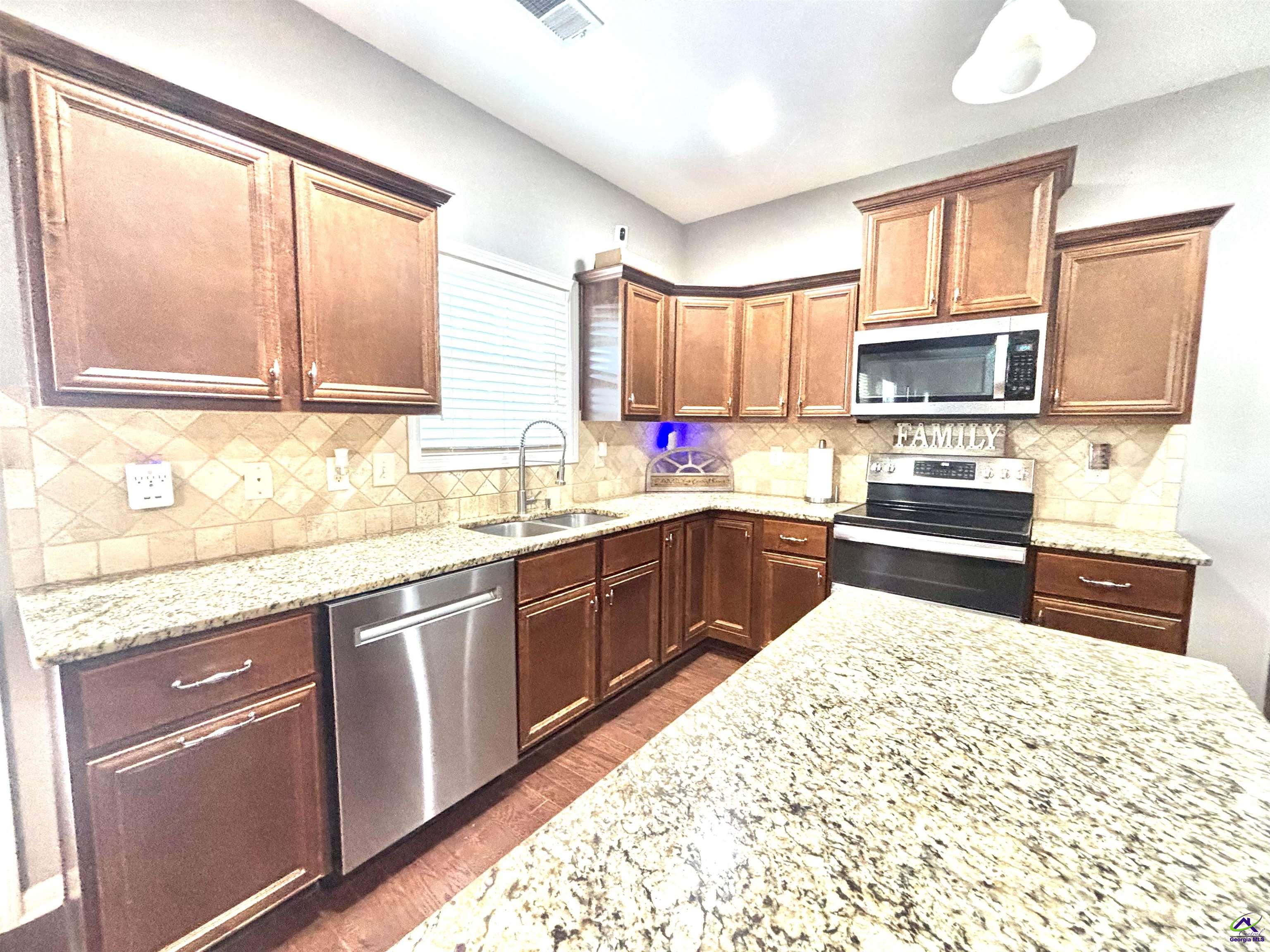 600 Post Oak Way Warner Robins, GA 31088 - Photo 24 of 50 a kitchen with stainless steel appliances kitchen island granite countertop a sink stove and cabinets