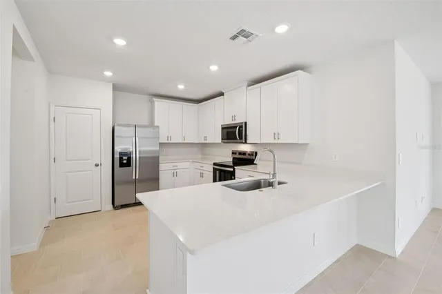 a kitchen with white cabinets and stainless steel appliances