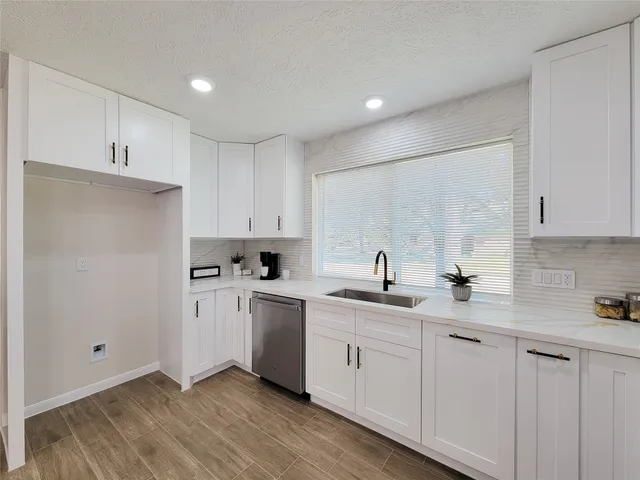 a kitchen with white cabinets appliances and sink