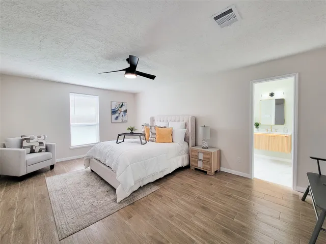 a bedroom with a bed and wooden floor