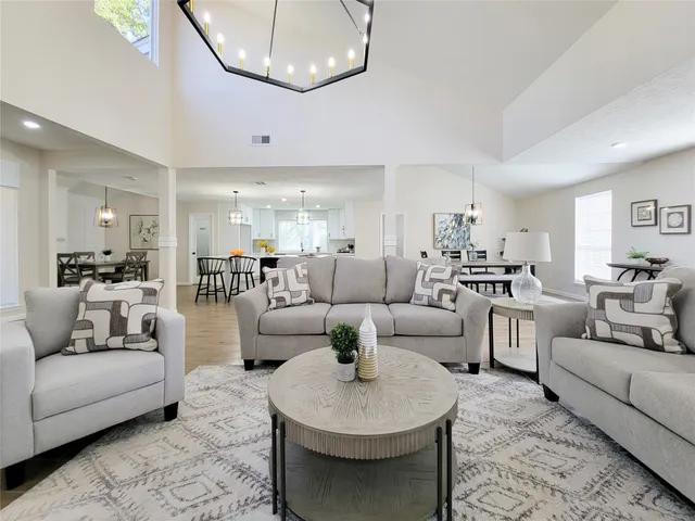 a living room with couches and a view of kitchen