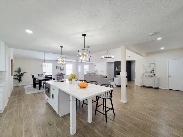 an open kitchen with wooden floor and stainless steel appliances