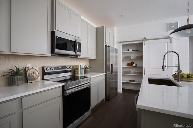 a kitchen with stainless steel appliances a stove microwave and sink