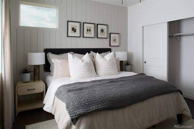 a bedroom with a bed and painting on the wall