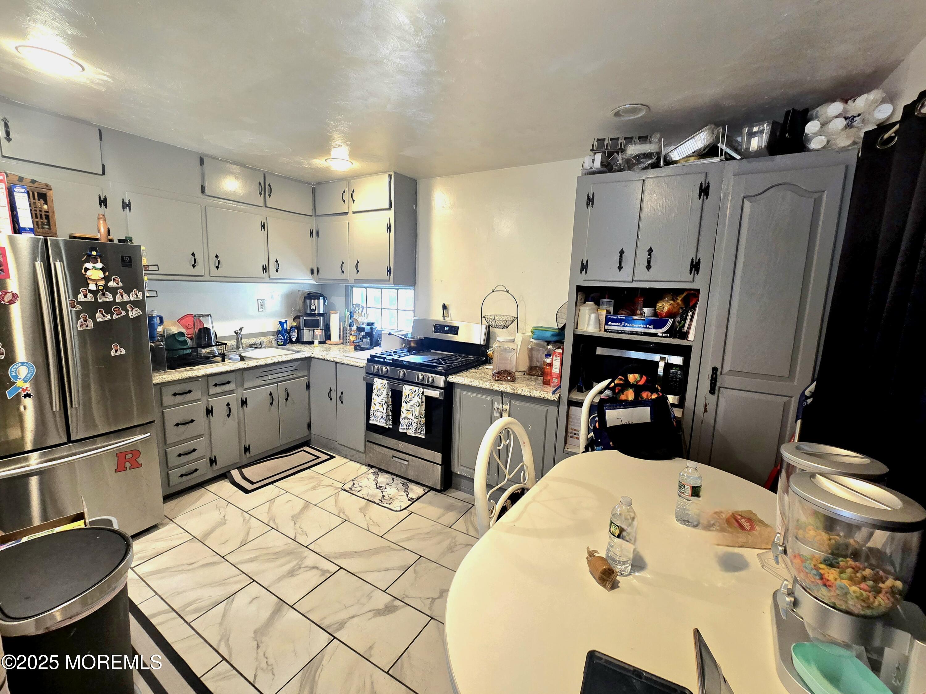 11 Trident Boulevard Neptune Township, NJ 07753 - Photo 9 of 25 a kitchen with stainless steel appliances kitchen island granite countertop a sink dishwasher a refrigerator a stove and white cabinets with wooden floor