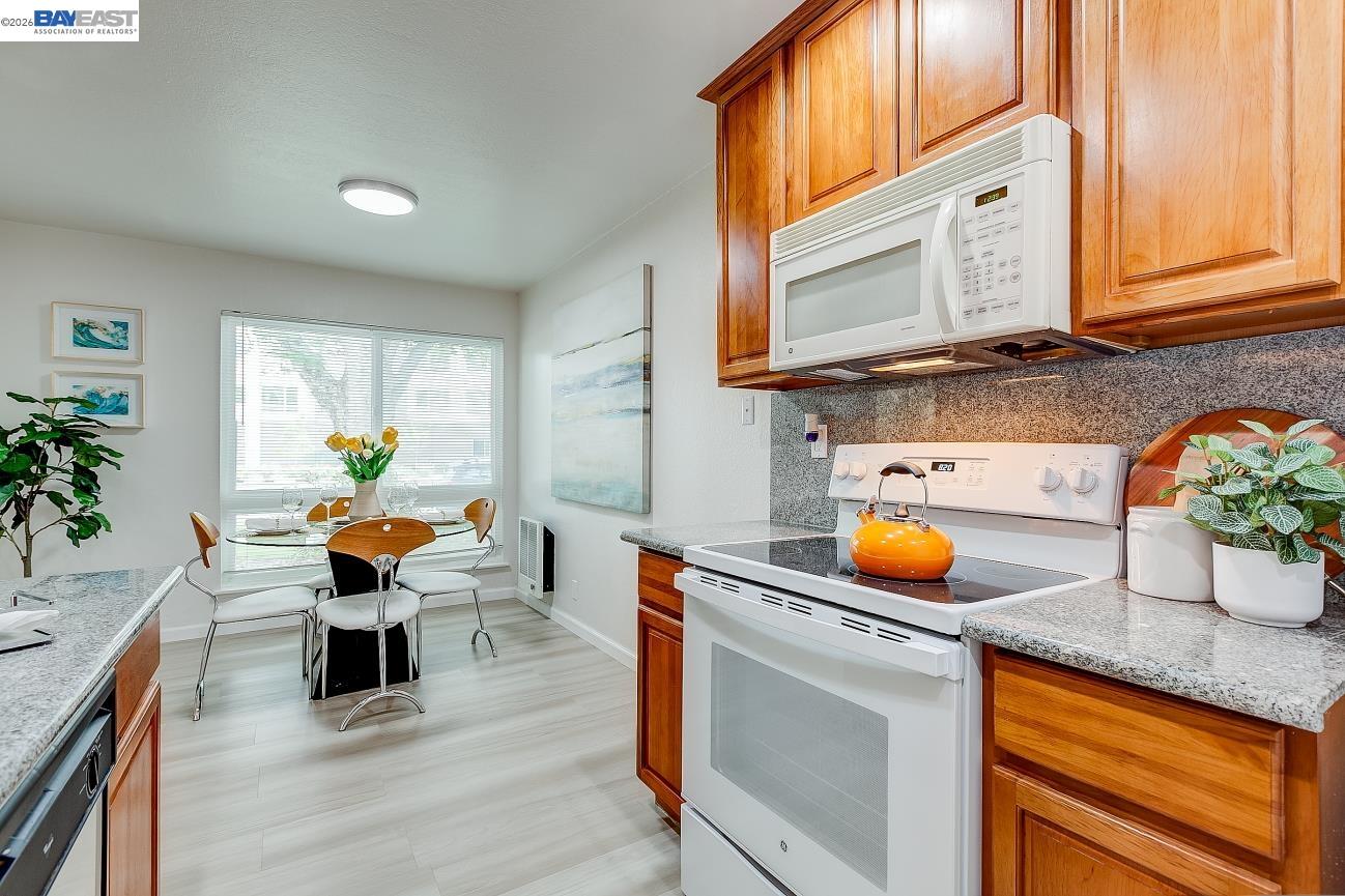 9005 Alcosta Boulevard, Unit 199 San Ramon, CA 94583 - Photo 33 of 57 a kitchen with stainless steel appliances granite countertop a stove a sink a dining table and chairs