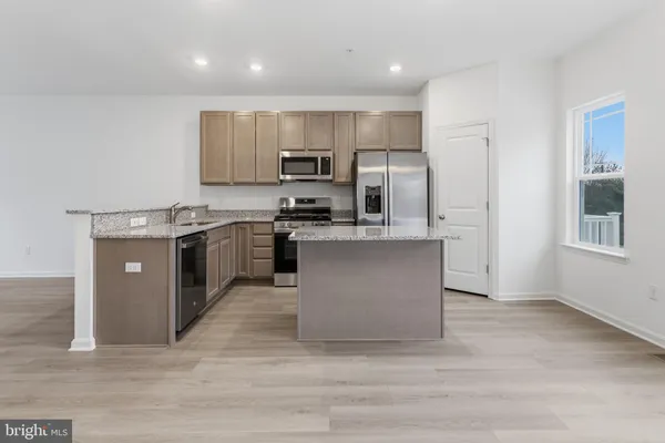 a kitchen with stainless steel appliances granite countertop a stove top oven a refrigerator and a sink