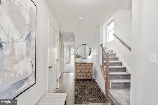 a view of entryway and hall with wooden floor