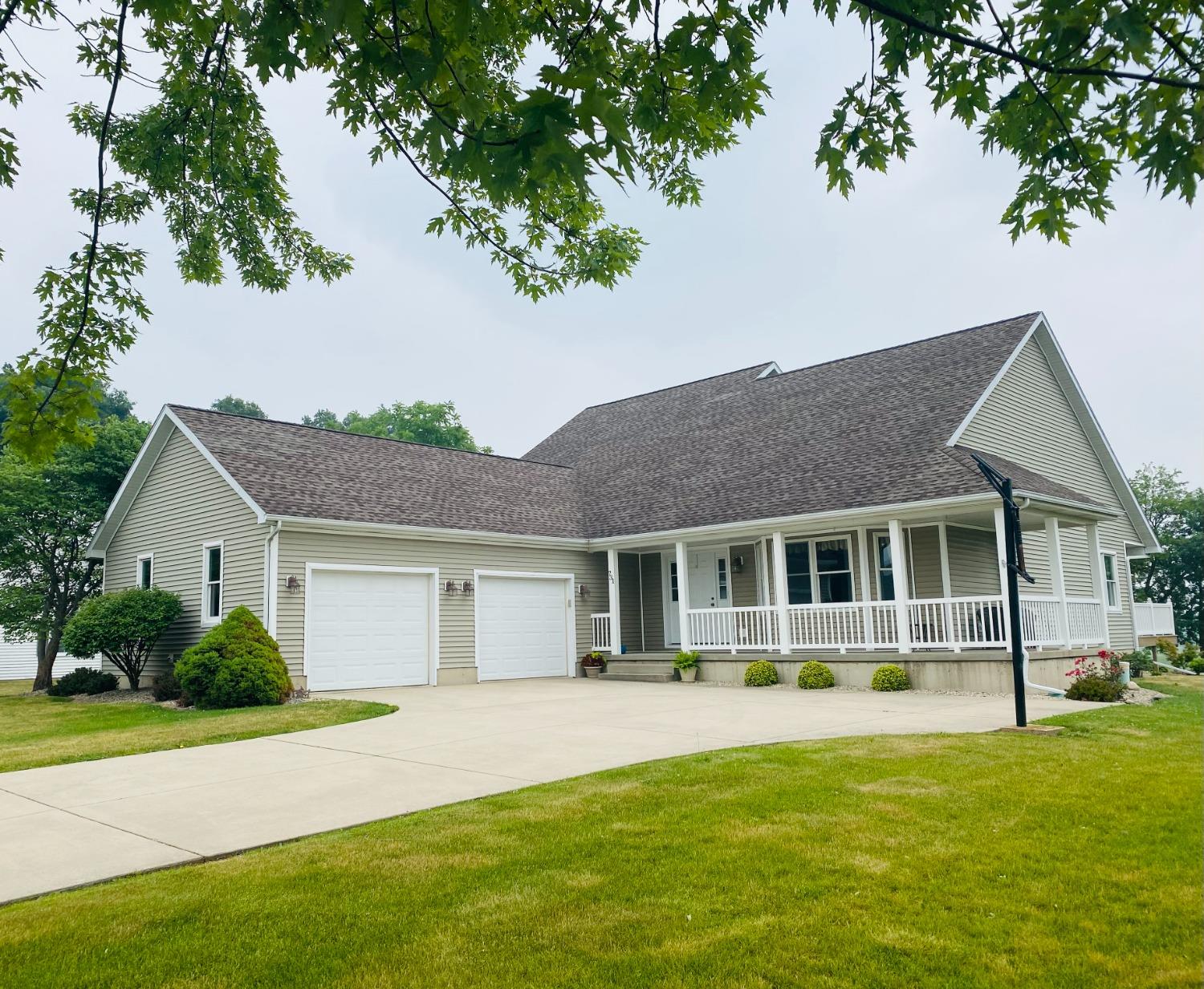a front view of a house with a yard and green space