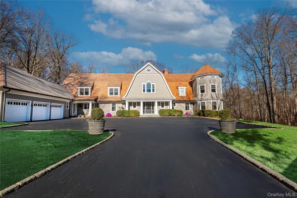 a view of a big house with a big yard and large trees