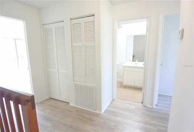 an empty room with wooden floor cabinet and front door