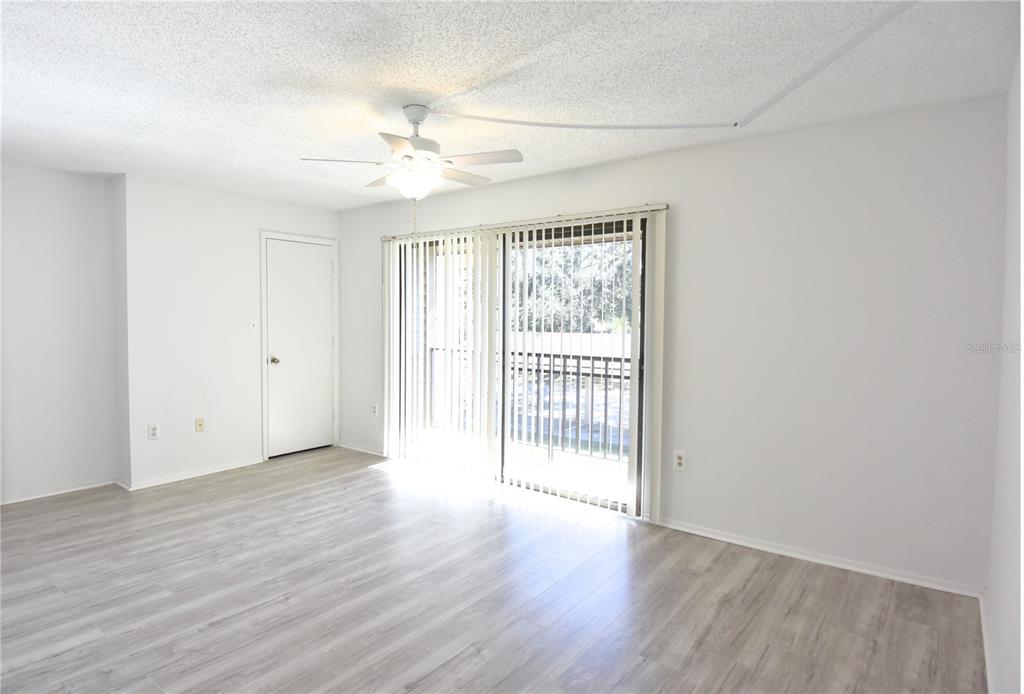 935 Sunridge Way, Unit B4 Sarasota, FL 34234 - Photo 16 of 45 a view of an empty room with wooden floor and fan