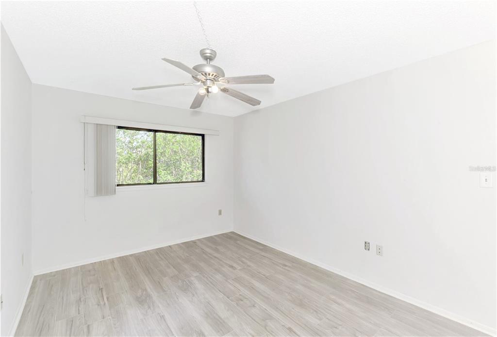 935 Sunridge Way, Unit B4 Sarasota, FL 34234 - Photo 28 of 45 an empty room with a window and a ceiling fan