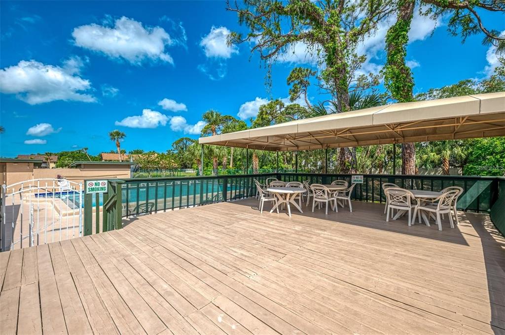 935 Sunridge Way, Unit B4 Sarasota, FL 34234 - Photo 45 of 45 a view of a patio with dining table and chairs with wooden floor