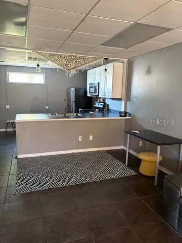 a view of kitchen with furniture and refrigerator