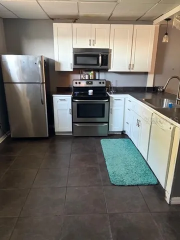 a kitchen with stainless steel appliances granite countertop a stove a sink and a refrigerator