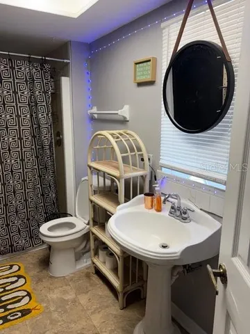 a bathroom with a sink a toilet and a mirror