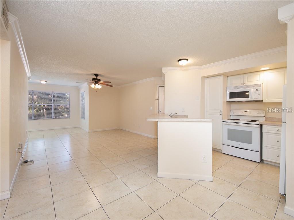 4606 Commander Drive, Unit 1124 Orlando, FL 32822 - Photo 2 of 16 a view of a kitchen with white cabinets and white appliances