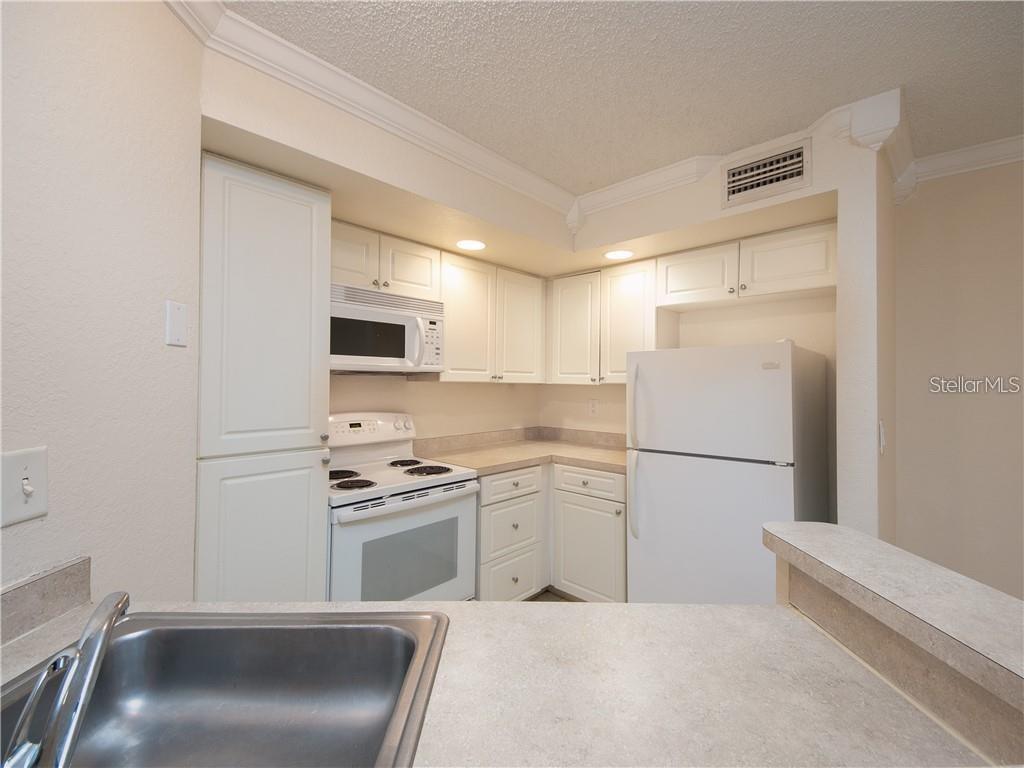 4606 Commander Drive, Unit 1124 Orlando, FL 32822 - Photo 3 of 16 a kitchen with a sink a stove and refrigerator