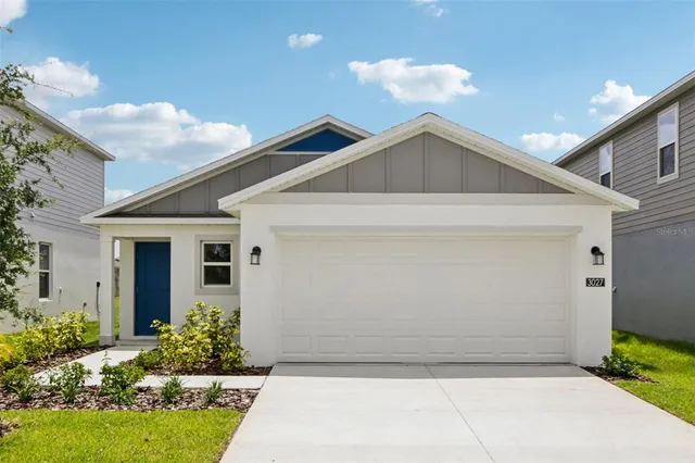 a view of a house with a yard and potted plants