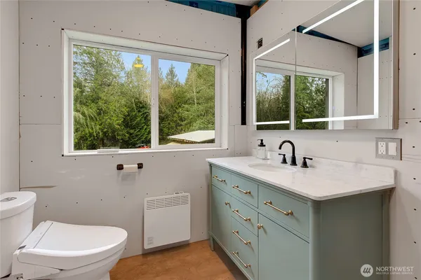 a bathroom with a granite countertop sink a large mirror and a window